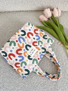Sac fourre-tout matelassé avec motifs en U colorés et surpiqûres en losange sur tissu blanc