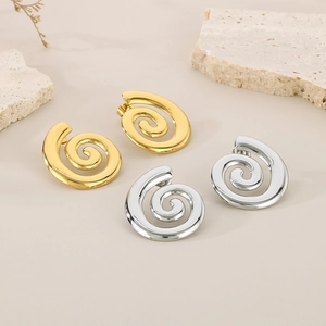 Makro-Detail von gedrehten Spiral-Ohrsteckern in poliertem Gold- und Silber-Finish