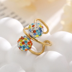 Detailed macro of golden spiral ring featuring two spheres with multicolor micro rhinestones