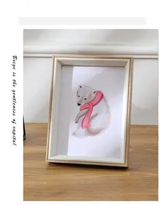 Detail showing natural wood texture of a Nordic photo frame with a cute polar bear illustration