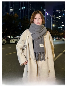 Close-up of grey tassel scarf texture with soft knit wool for winter fashion wear
