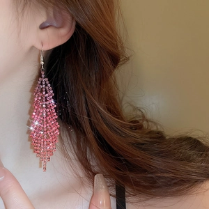 Detail of pink rhinestone fringe earrings on model with sparkling tassel pendant