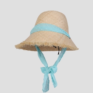 Detail of raffia sun hat featuring light blue polka dot mesh ribbon and frayed edge