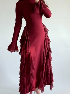 Dettaglio dell'abito bordeaux a maniche lunghe con balze a strati e tessuto chiffon