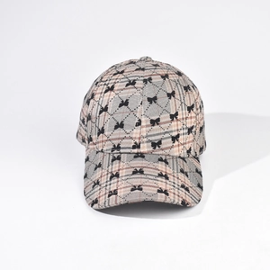 Close-up of checkered baseball cap with black bow pattern on beige fabric
