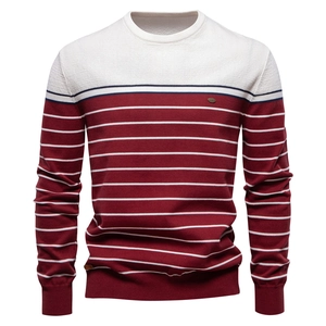 Detailed close-up of striped color-block knit sweater texture in white and burgundy red