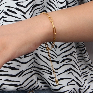 Elegant gold paperclip link bracelet with adjustable chain worn on wrist