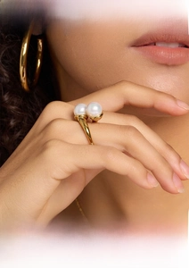 Detailed view of an adjustable gold stainless steel ring with elegant dual white pearls