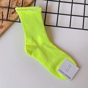 Detail shot of neon green crew socks with roll cuff design and premium branding label