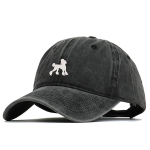 Detail of a washed cotton baseball cap featuring a white poodle silhouette embroidery