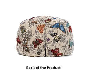 Detailansicht der Rückseite eines weißen Baretts mit bunter Schmetterlingsstickerei und Verstellgurt