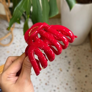 Close-up of a large red glossy pumpkin hair claw clip showing durable multi-tooth design