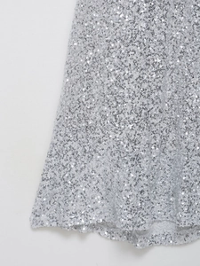 Gros plan sur les paillettes argentées denses d'une robe de vacances élégante
