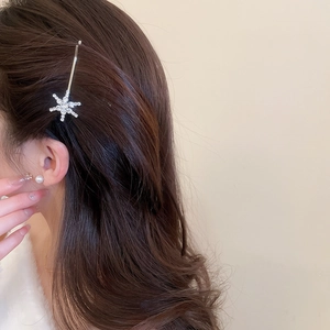 Detailed view of a glittering crystal star hairpin worn by a model for elegant hair styling