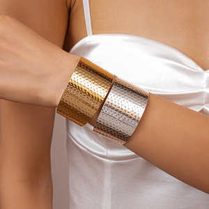 Macro detail of gold and silver hammered metal cuff bracelets with textured finish