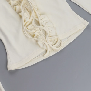 Détail macro du haut blanc crème à volants avec texture tricotée et liens de serrage