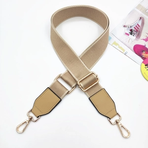Close-up of khaki wide canvas shoulder strap with gold metal hooks and PU leather ends
