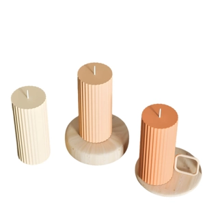 Ribbed pillar candles set in white, pink, and terracotta with decorative display bases