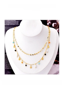 Detail view of double-layer titanium necklace with stars, pearls and colored beads