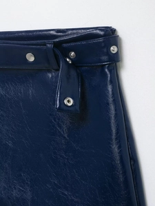 Détail d'une mini-jupe en similicuir bleu marine avec ceinture assortie et boucles argentées