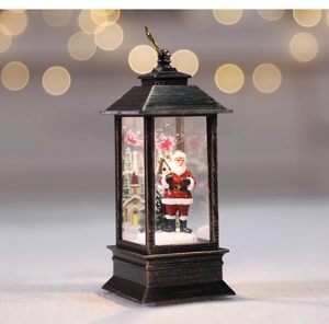 Macro view of vintage bronze Christmas lantern with Santa Claus and snow scene inside