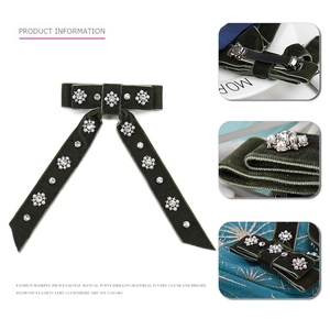 Detailed view of dark green velvet bow hair clip with crystal and pearl embellishments