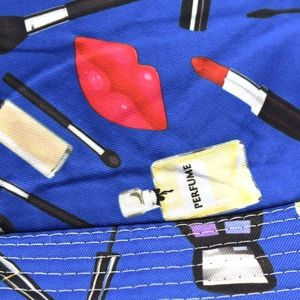 Detailed view of blue bucket hat featuring vibrant makeup patterns and stitching