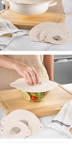 Set of various sized beige silicone vacuum lids on a kitchen marble countertop