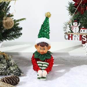 Close-up of a Christmas elf doll with red and green sequins in a festive holiday scene