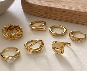 Macro detail of 925 sterling silver gold rings with pearls and twisted textures