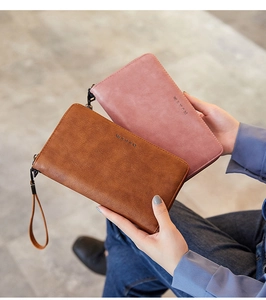 Detailed view of pink and brown vintage oil wax leather long wallets with wrist straps