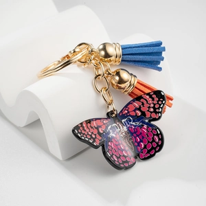 Chic butterfly keychain with blue and orange tassels on a white display stand