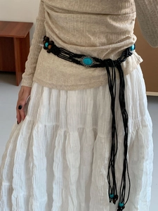Detail of bohemian waist belt featuring turquoise stones, wooden beads and long tassels