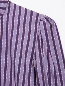 Makroaufnahme der lila gestreiften Bluse mit Polka Dots und Falten am Schulterbereich