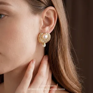 Vintage gold heart earrings with white pearls and sparkling crystals on model