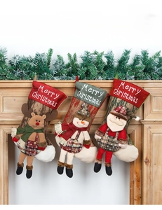 Close-up of linen Christmas stockings with Santa, Snowman, and Reindeer 3D dolls
