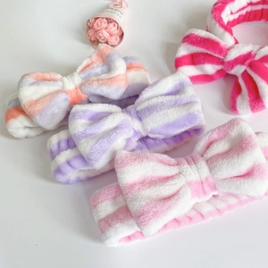 Detailed view of colorful striped coral fleece headbands with large soft bows