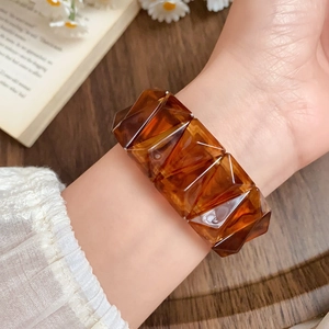 Detail of amber acrylic geometric faceted elastic bracelet with vintage resin texture