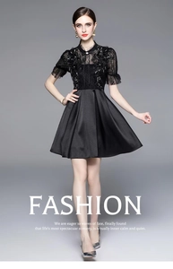 Detailed view of luxury black lace dress featuring heavy beading and satin pleated skirt