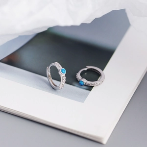 Macro shot of silver S925 earrings with blue opal stone and sparkling side diamonds
