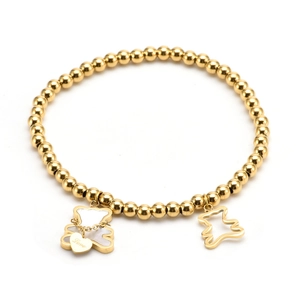 Gold beaded bracelet with mother of pearl bear charm and heart pendant on white background