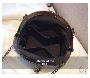 Detail view of the black retro shell bag interior with pockets and chain strap
