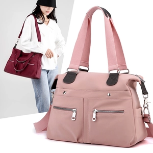 Close-up of pink nylon travel bag and model carrying the burgundy variant on shoulder