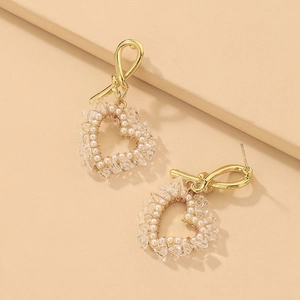 Detail of heart drop earrings with wire-wrapped faux pearls and crystals in gold plating