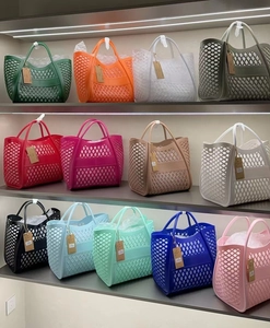 Detailed view of hollow silicone tote bags in various colors on a retail display shelf