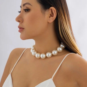 Close-up of oversized pearl choker with sparkling rhinestone spacers on a model