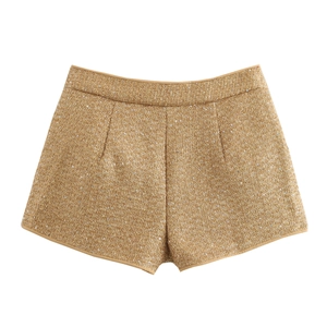 Close-up of golden brown tweed shorts featuring shimmering sequins and textured knit fabric