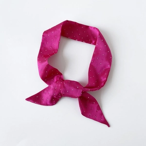Detailansicht eines fuchsiafarbenen Satin-Halstuchs mit silbernen Strasssteinen und Schleife