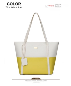 Detail of yellow and white leather tote bag featuring a metal buckle and hanging tag