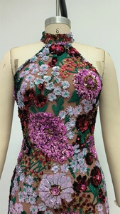Détail de la broderie florale en paillettes sur la robe dos nu en maille avec col haut